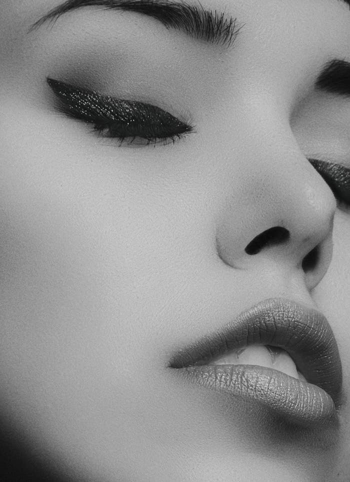 Artistic black and white close-up portrait of a womans face with glamorous makeup.